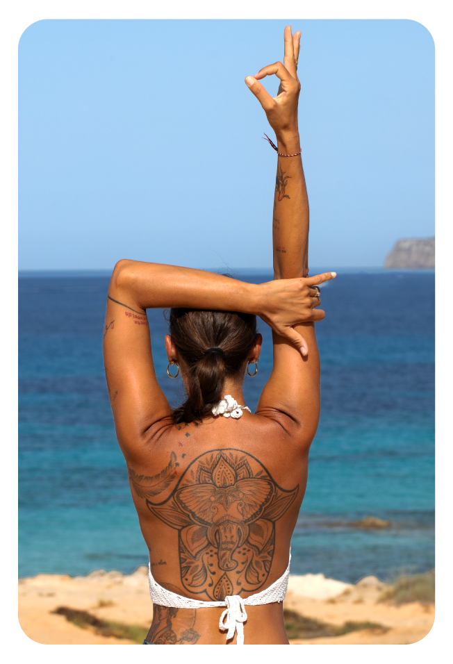 Cristina, insegnante di Yoga, che esegue una posizione di yoga guardando il mare